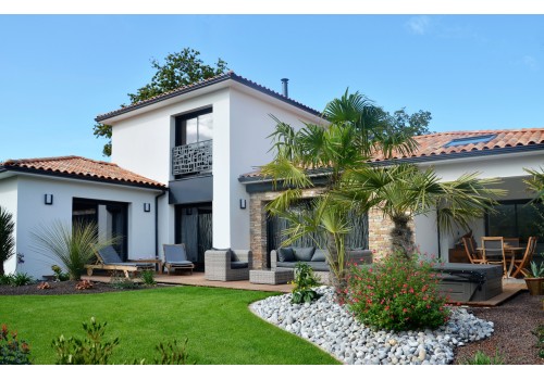CONSTRUCTIONS DE L'ERDRE (CDE) vous présente une construction de maison individuelle traditionnelle à PORNIC, maison avec cuisine d'été ouverte sur le jardin exotique, parement pierre et menuiseries alu anthracite pour un aspect design